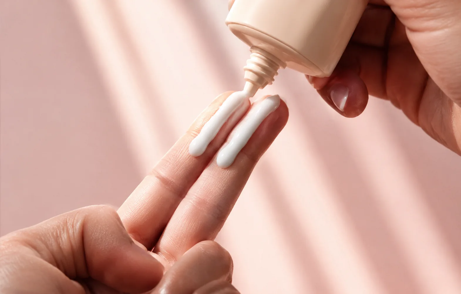 Application d'une crème solaire SPF 50 sur le bout des doigts, illustrant la règle des deux doigts